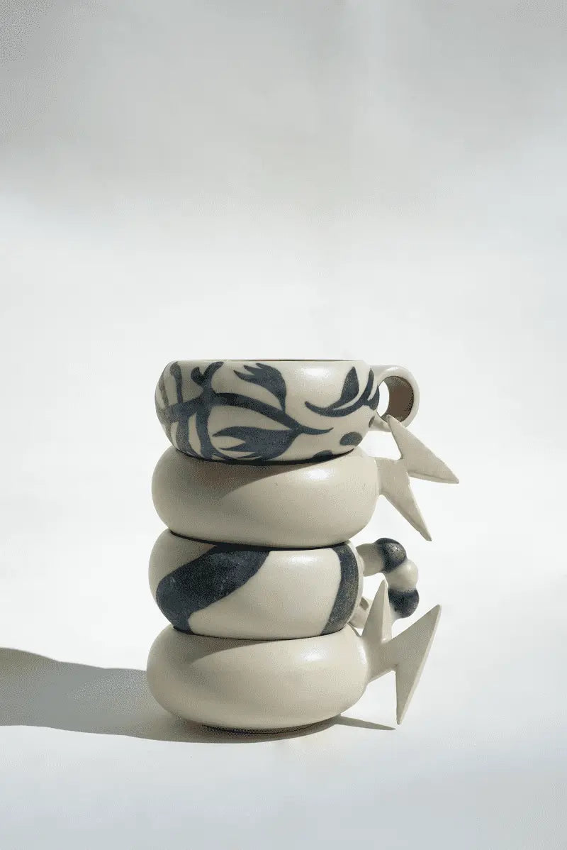 Stack of ceramic cups with patterns on a white background